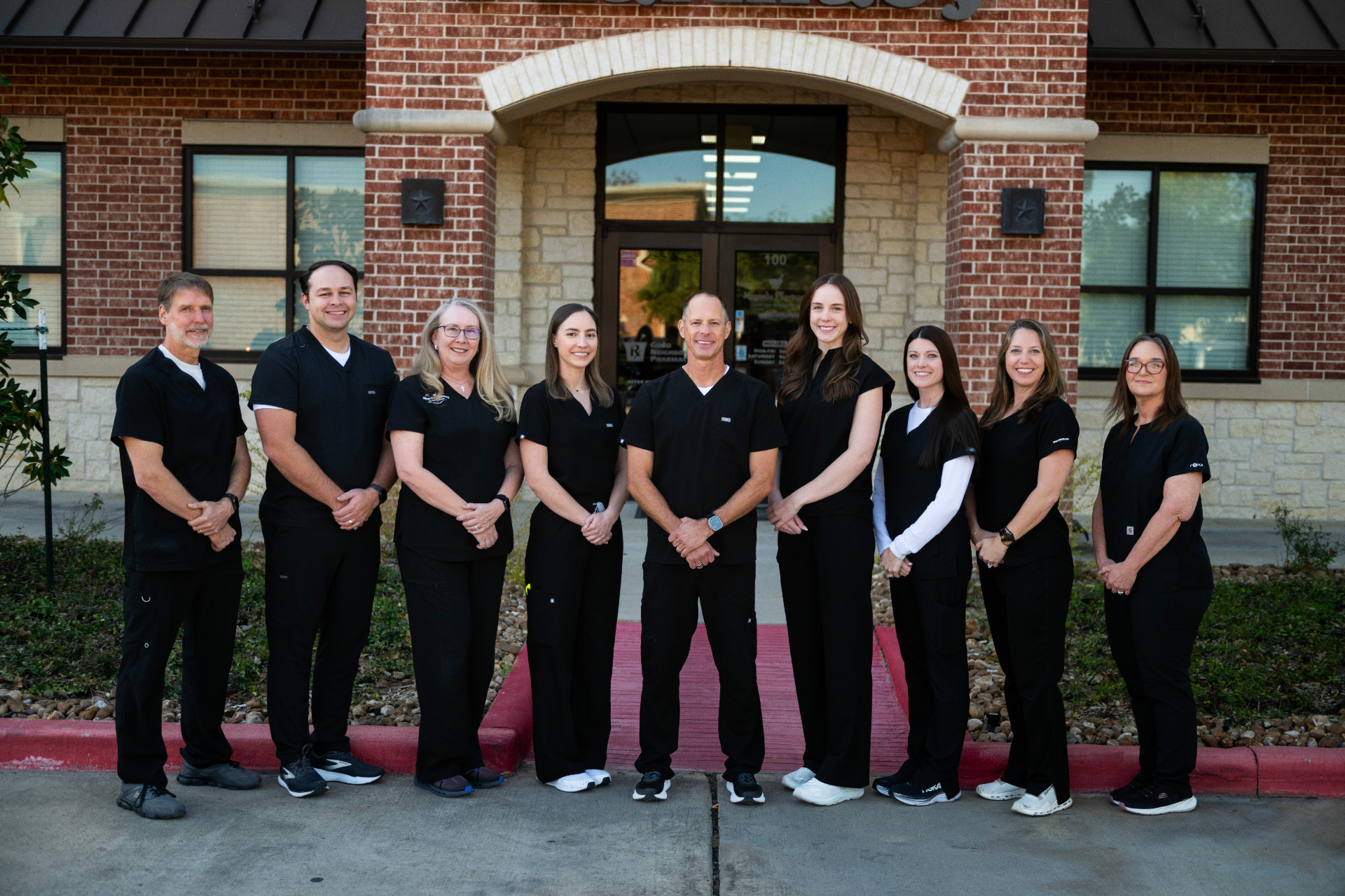 The Magnolia Pharmacy team — nine pharmacists outside the Magnolia, TX storefront
