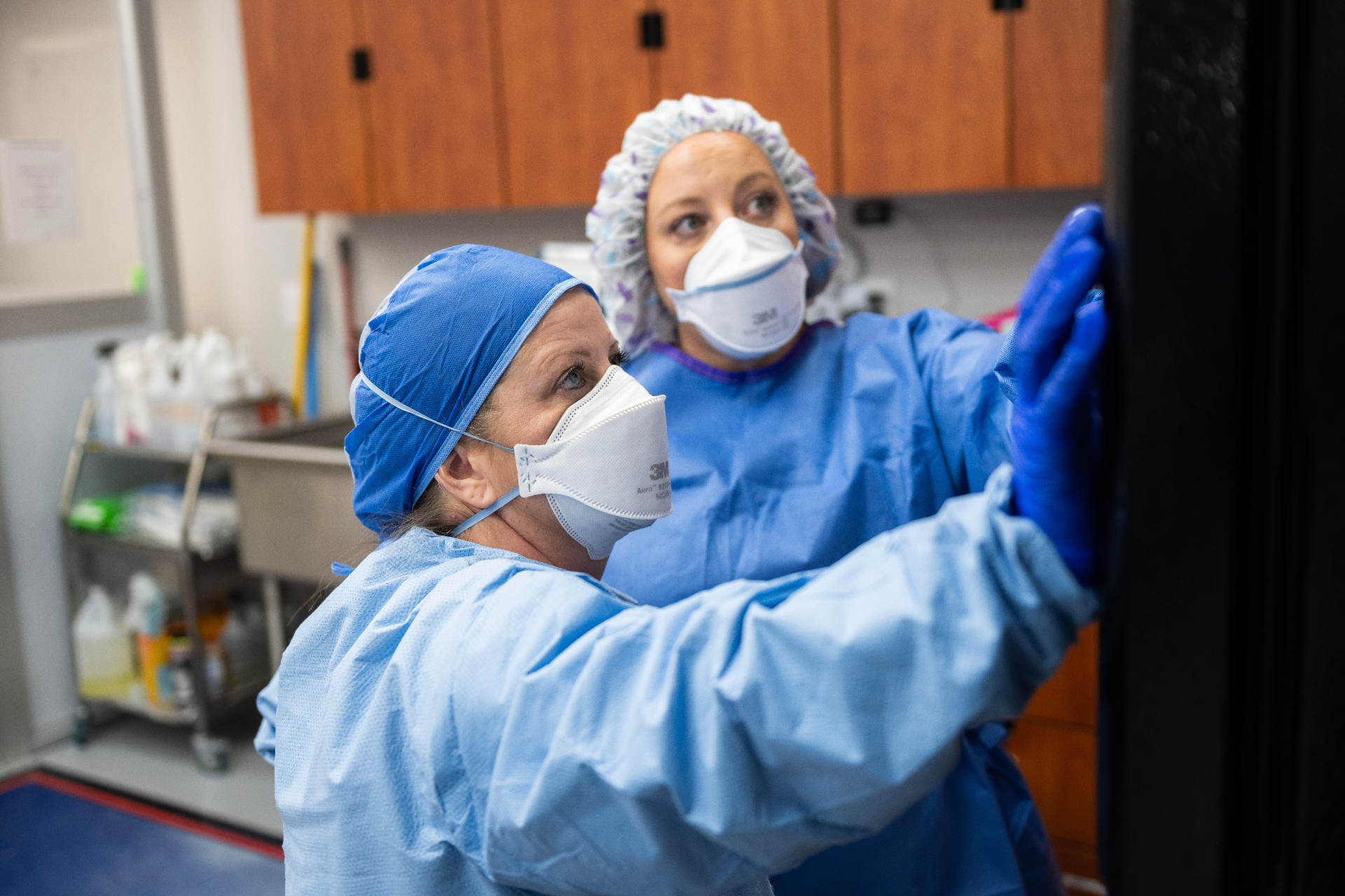 Pharmacy technicians in sterile scrubs working in the Magnolia Pharmacy compounding lab